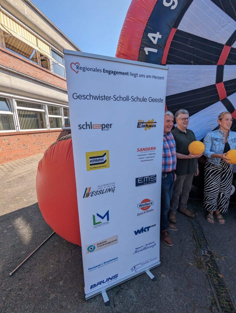 Sponsorentafel vor der Fußball-Dartscheibe mit Gästen