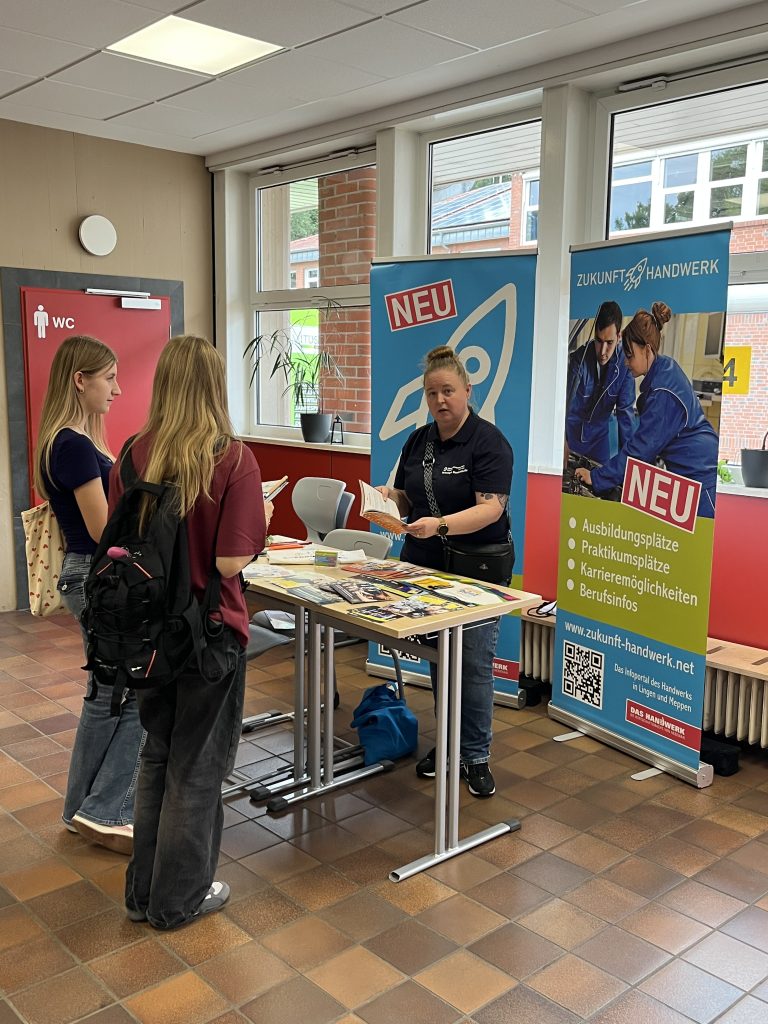Zwei Besucherinnen informieren sich an einem Stand zum Handwerk.