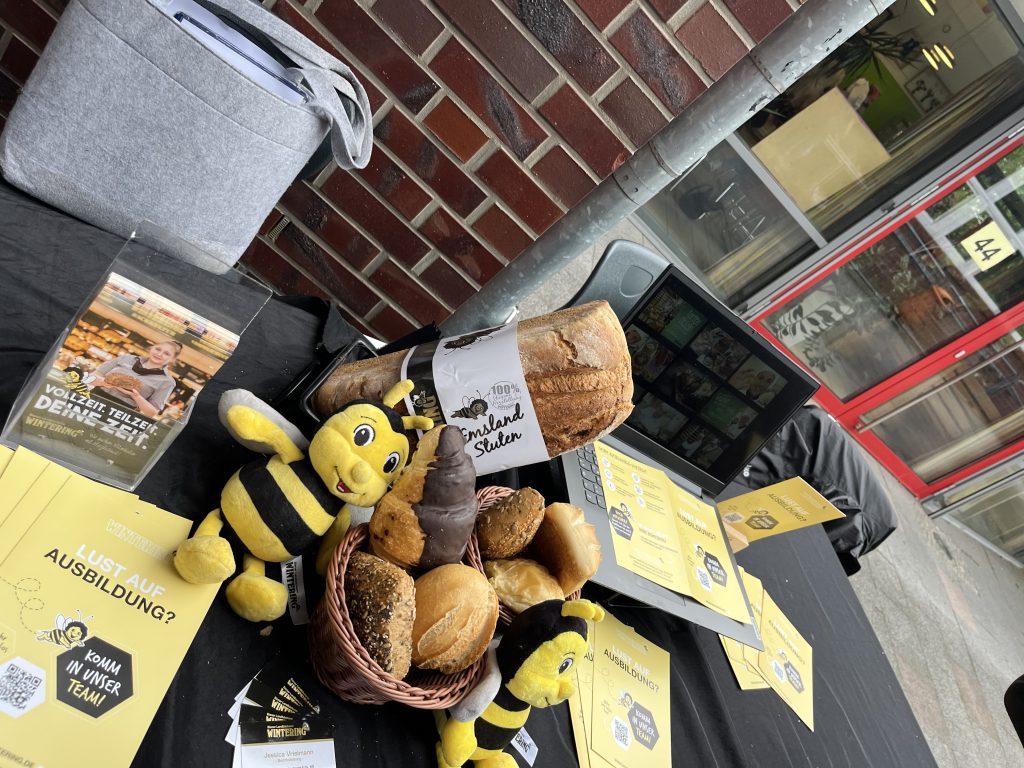 Auslage mit Brot, Gebäck und Informationsmaterial auf einem Messestand.